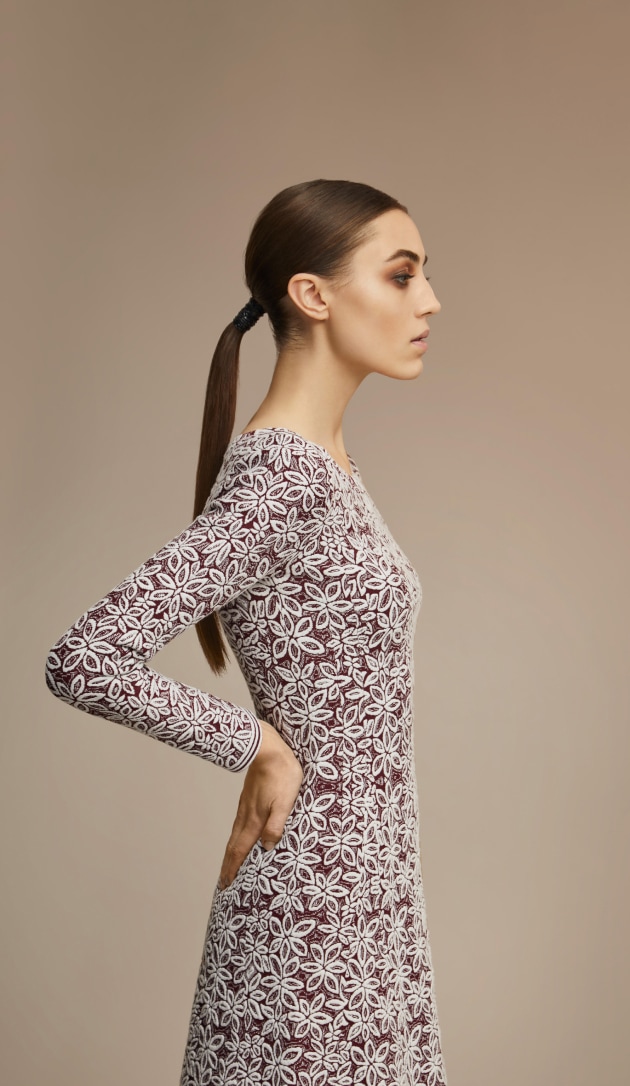 A woman wearing a dress with a flower pattern